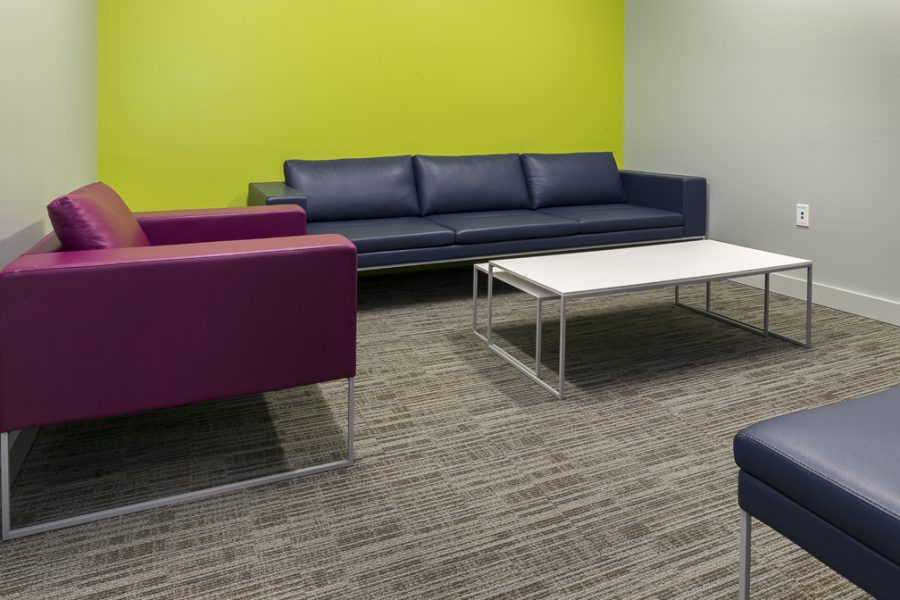 Small meeting room with couches and bright walls.