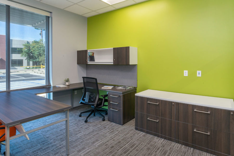 Private office with wood laminate surfaces with bright accent wall