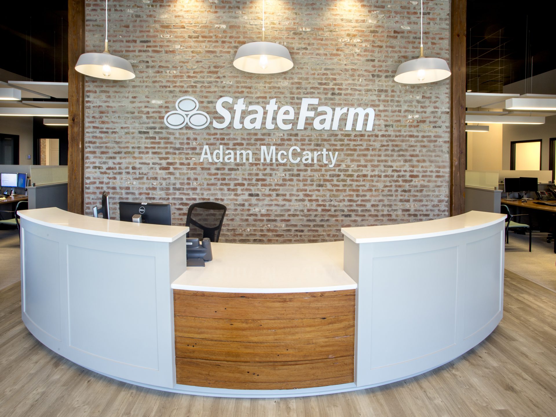 Adam McCarty State Farm front desk. Exposed brick and wood details.