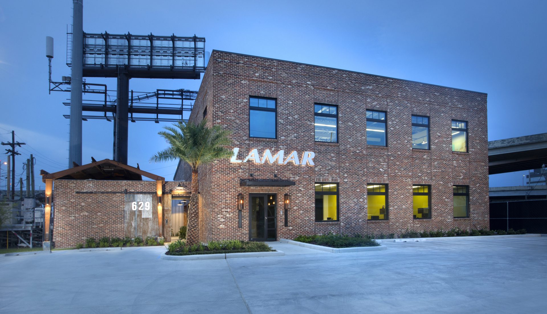 Lamar Advertising - New Orleans exterior at dusk with illuminated Lamar signage.