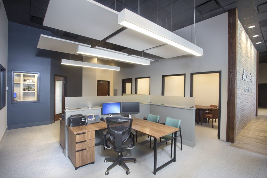 Floating acoustical clouds over open desk spaces.