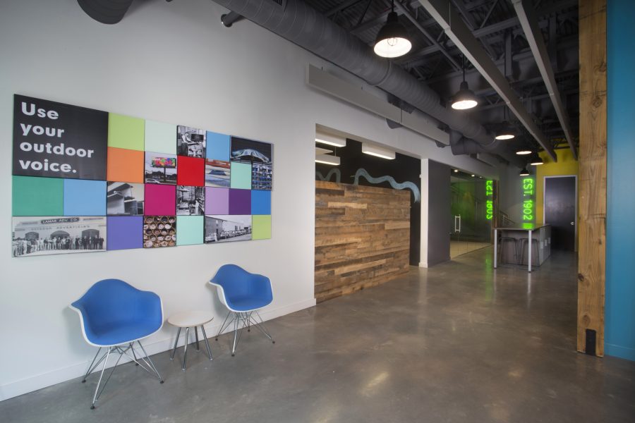 Entry corridor with colorful artwork and bright blue chairs