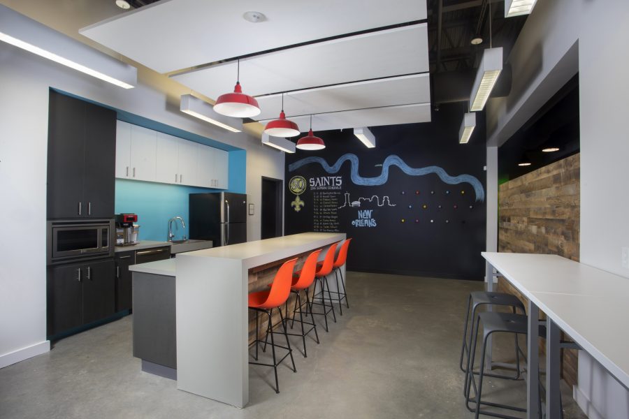 Bright break room with chalkboard wall and red pendant lights