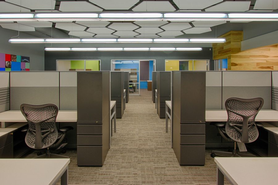 Open office space with desks and hexagon ceiling tiles.