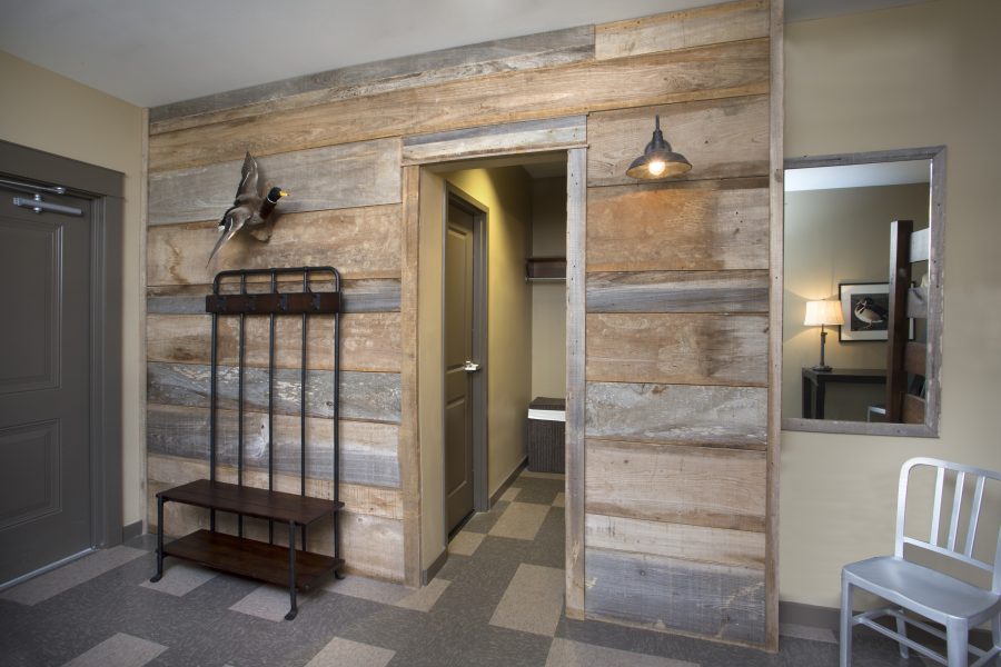 Guest room including large exposed wood wall.