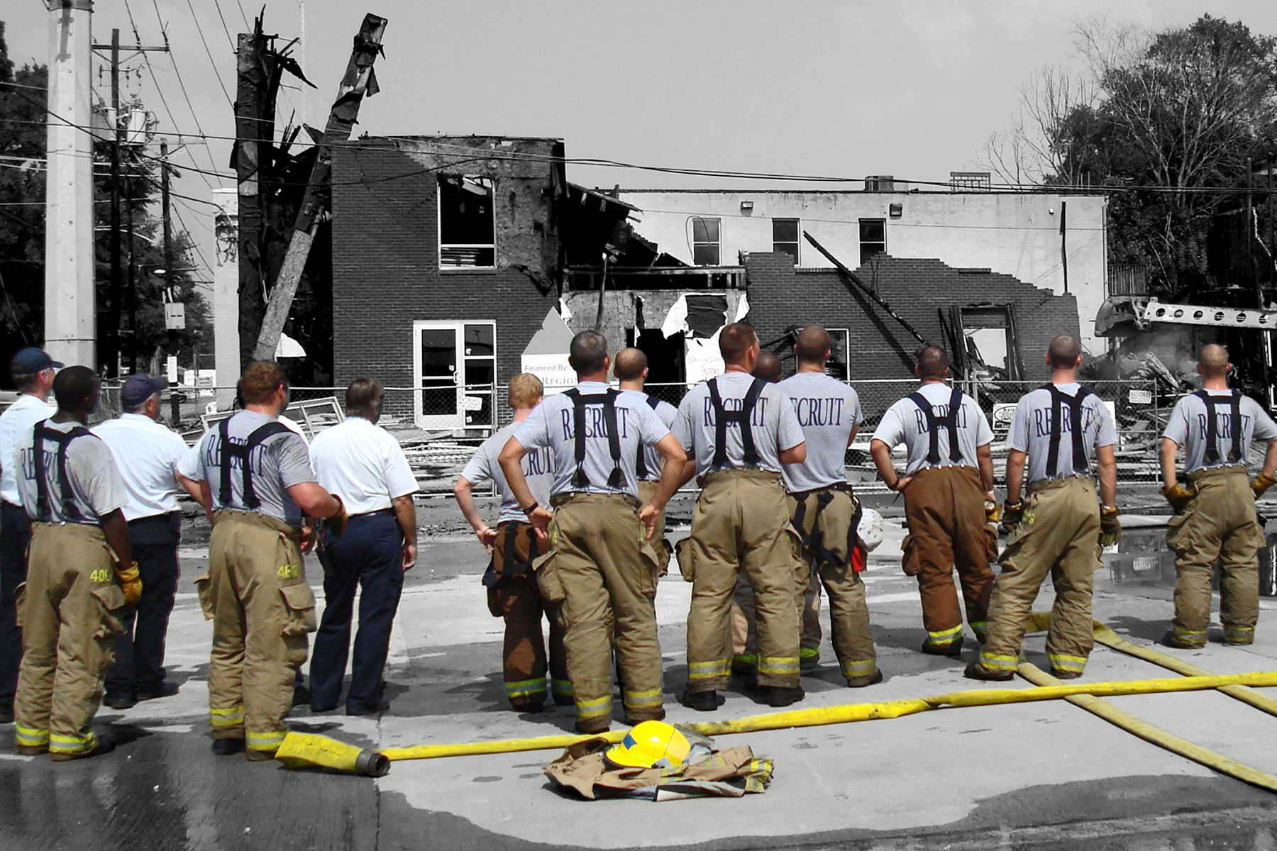 Firefighters looking at a burned building