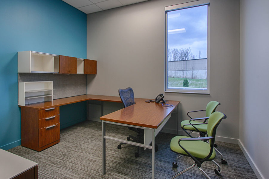Interior of private office with green chairs and bright blue accent wall