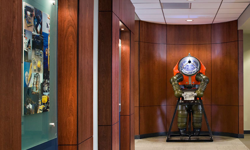 Wood veneer panels in corridor with display of dive suit